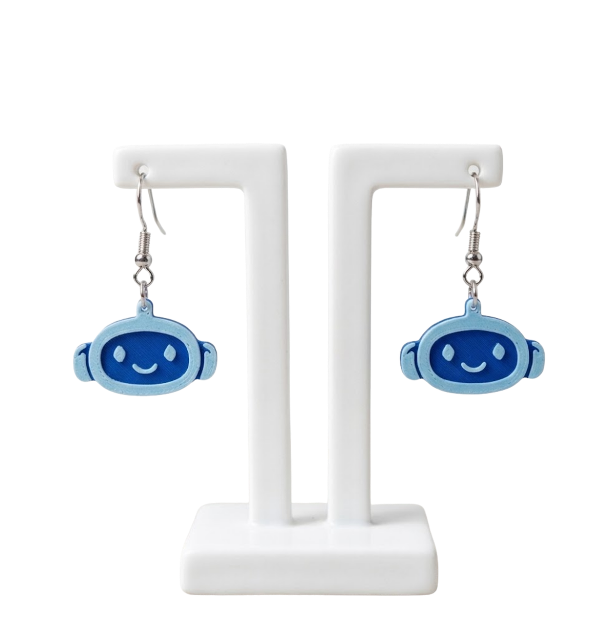 Two-tone blue robot-face 3D-printed dangle earrings on a white display stand