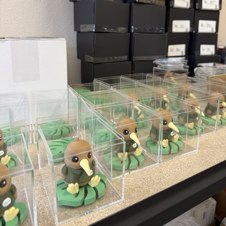 Custom kiwi figurines in acrylic display boxes, packed for shipping.Custom Collectibles